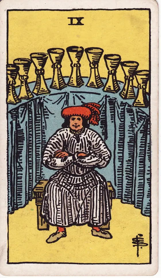 Nine of Cups tarot card from the Rider-Waite-Smith deck: a satisfied man seated with folded arms before an arc of nine cups.