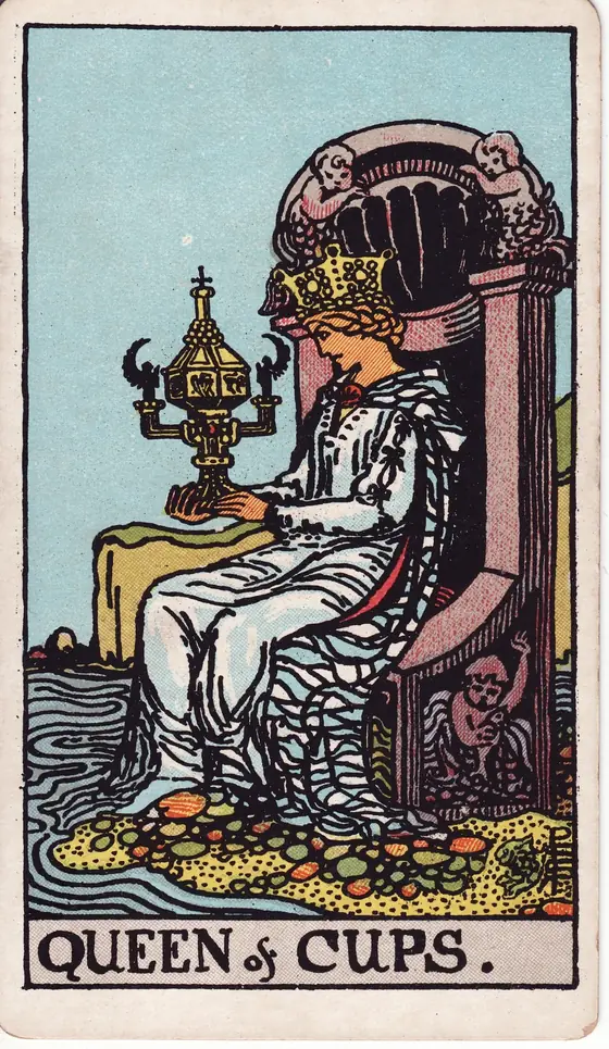 Queen of Cups tarot card from the Rider-Waite-Smith deck: a woman enthroned at the shore, gazing into an ornate lidded cup.