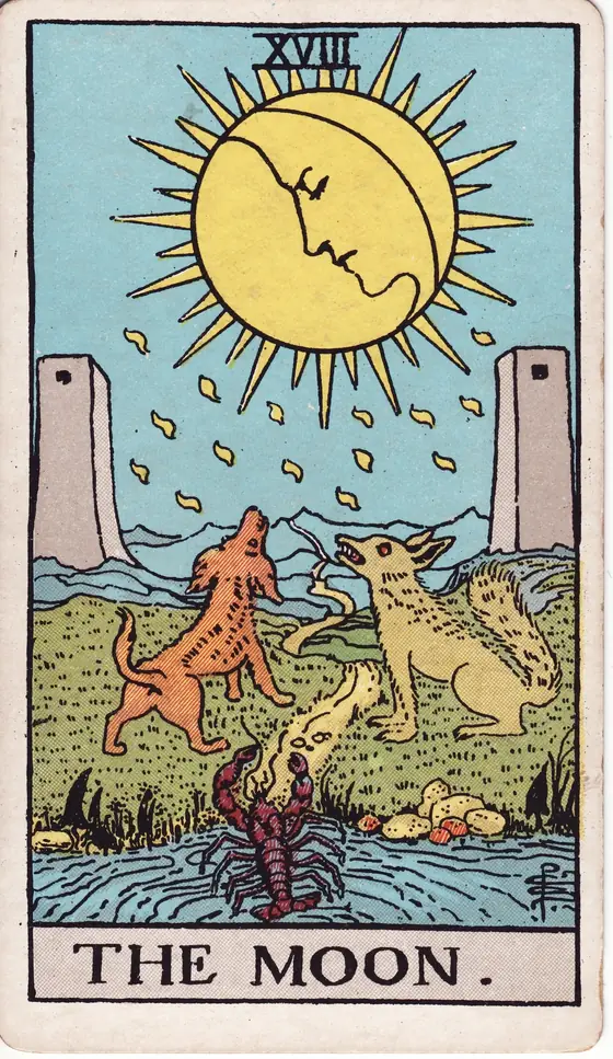The Moon tarot card from the Rider-Waite-Smith deck: a face in the moon above two towers, a dog and a wolf howling and a crayfish crawling from the pool.