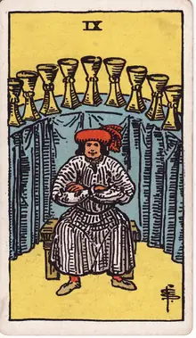 Nine of Cups tarot card from the Rider-Waite-Smith deck: a satisfied man seated with folded arms before an arc of nine cups.