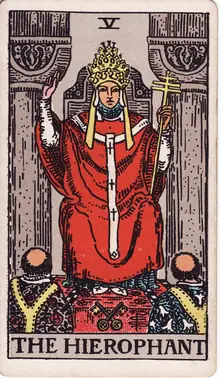 The Hierophant tarot card from the Rider-Waite-Smith deck: a robed priest raising a blessing between two pillars while two acolytes kneel below.