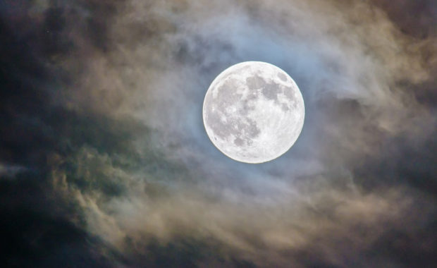 full moon in partially clouded sky