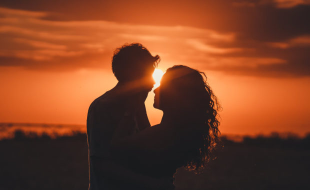 silhouette of couple holding each other in sunset