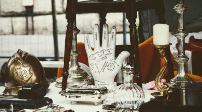 picture of palmistry hand on table surrounded by objects