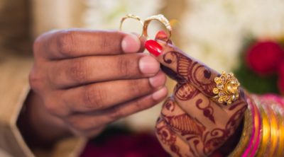 two hands holding wedding rings